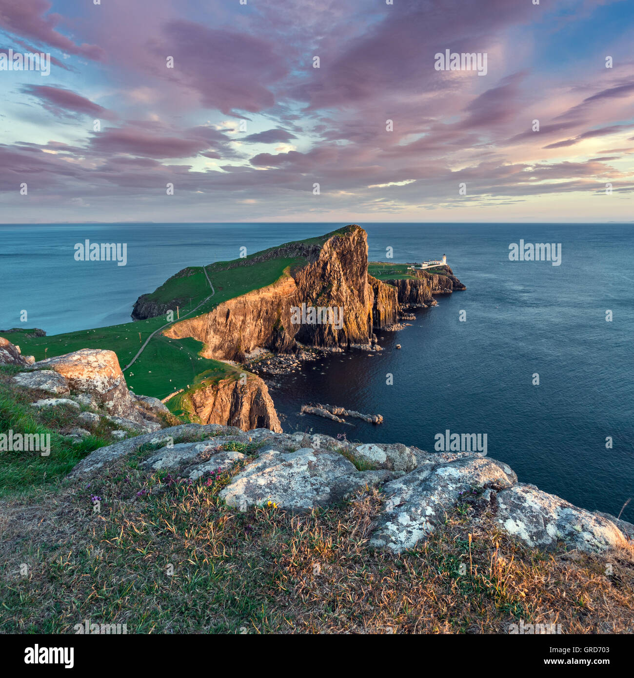 Tramonto nuvole sopra Neist Point e faro sull'Isola di Skye in Scozia Foto Stock