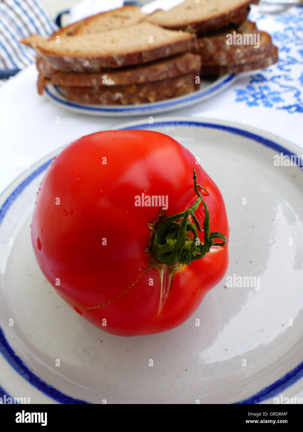 Rosso Pomodoro su una piastra, servita con pane Foto Stock