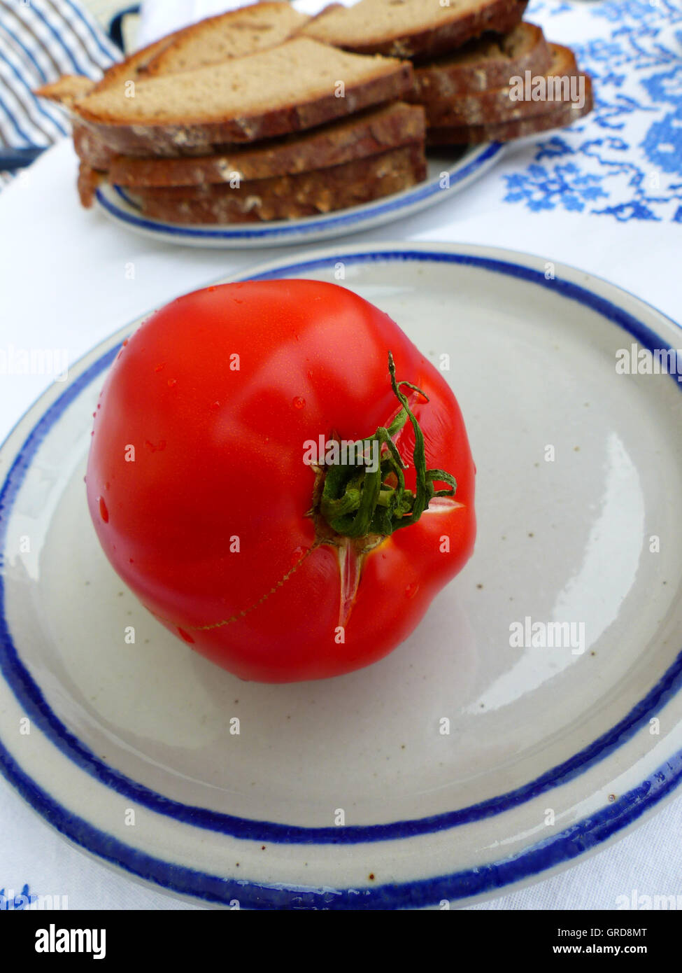 Rosso Pomodoro su una piastra, servita con pane Foto Stock
