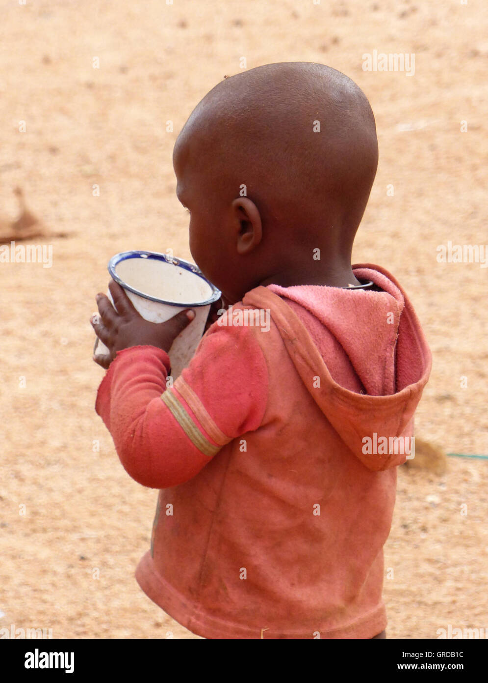 Little Boy di bere da un bicchiere, Himba, Namibia Foto Stock