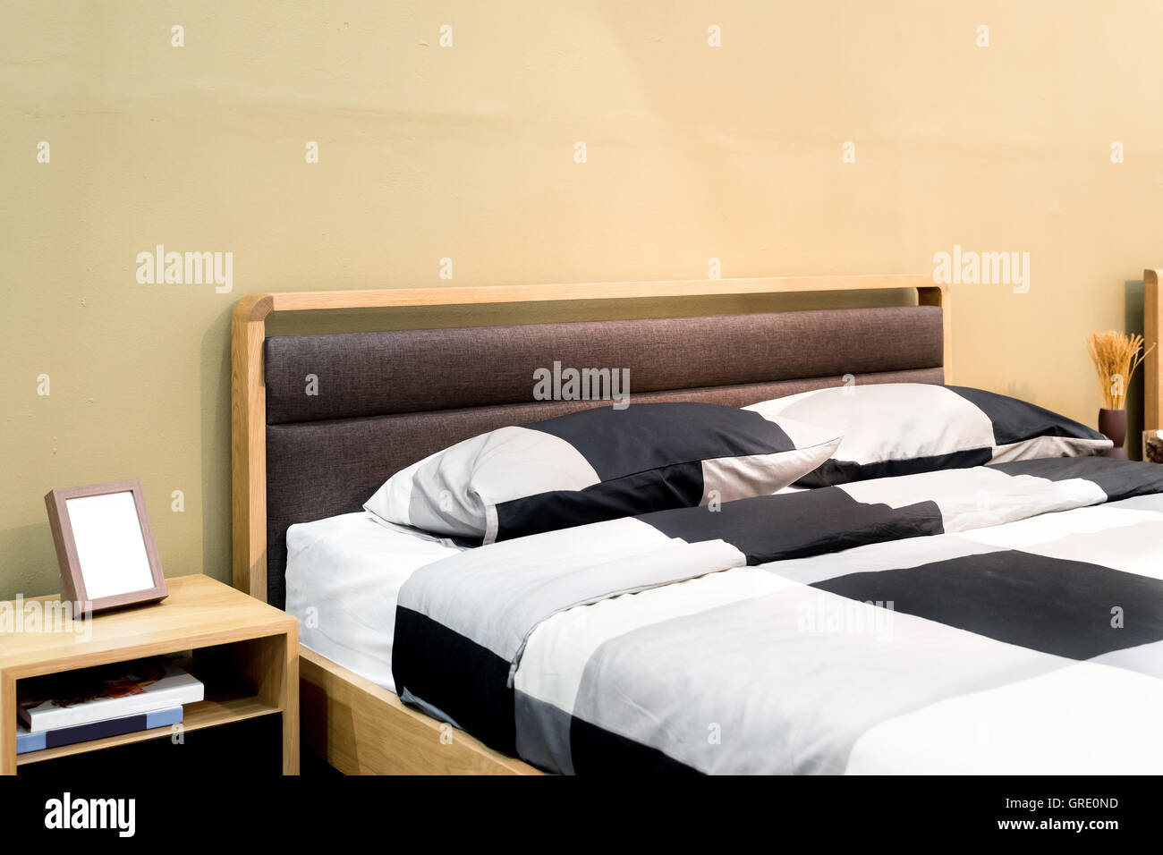 Letto di scacchi con cuscino e ripiano in camera da letto moderna. Camera da letto interno Foto Stock