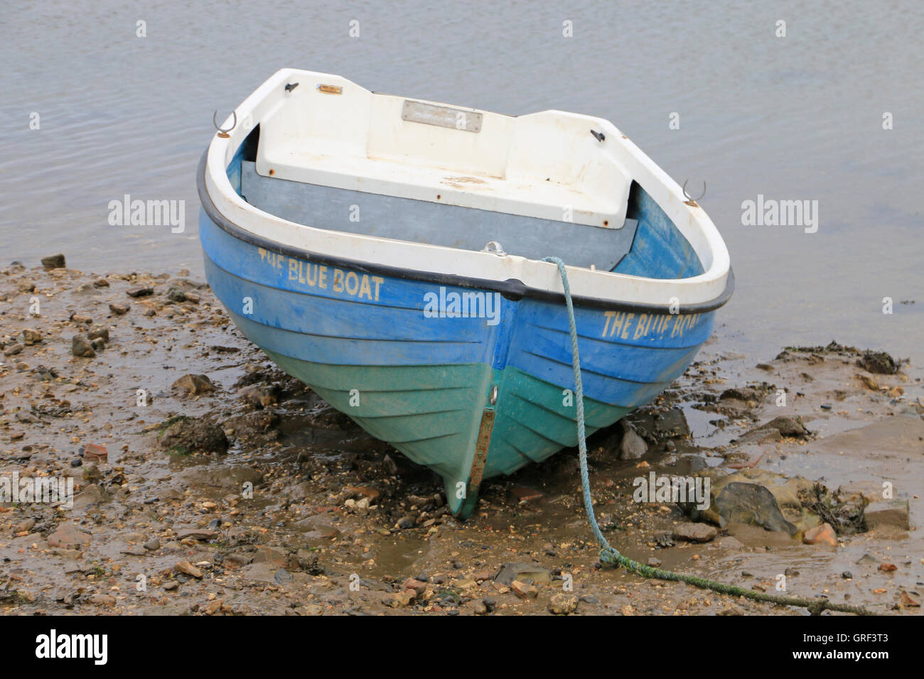 Il blu e il verde dinghy trainato fino al porto Foto Stock