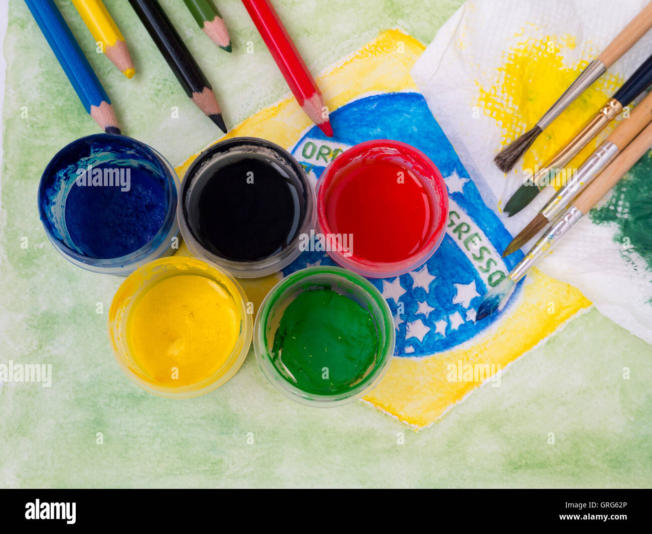 Vernici, spazzole, matite e e colorate con vernici tessuto sulla bandiera brasile la pittura ad acquerello Foto Stock