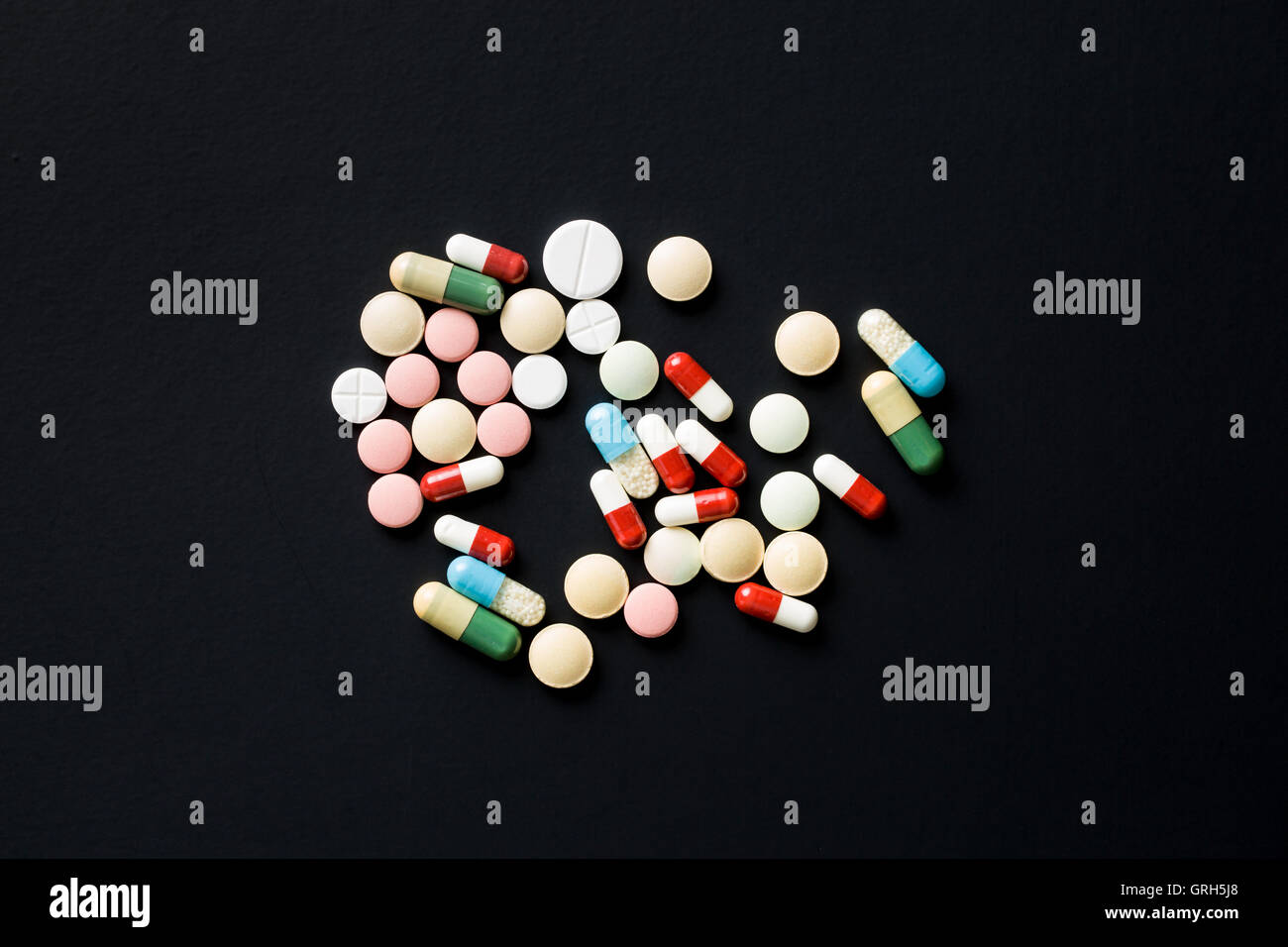 Le diverse pillole sulla tavola nera. Vista dall'alto. Foto Stock