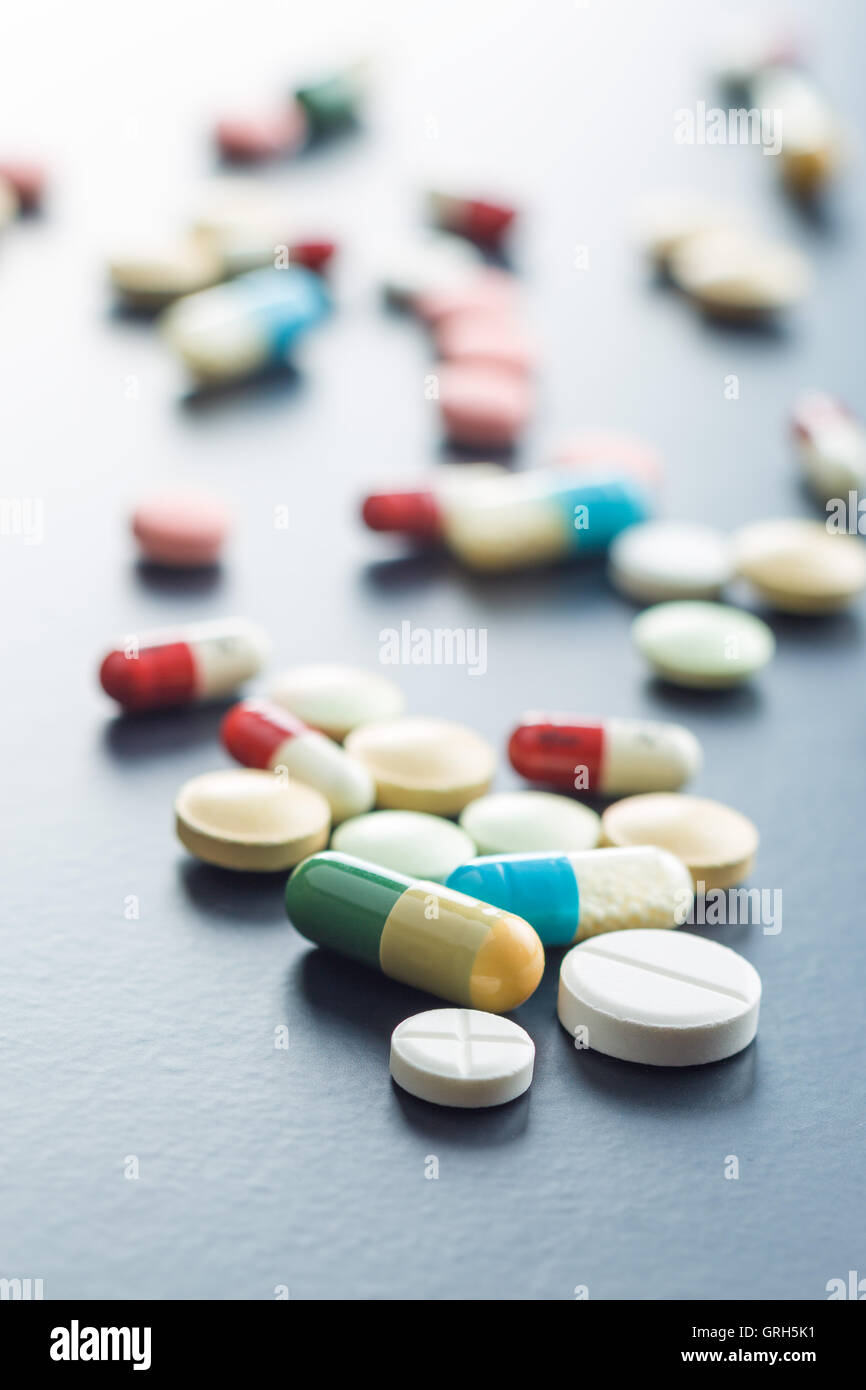 Le diverse pillole sulla tavola nera. Foto Stock