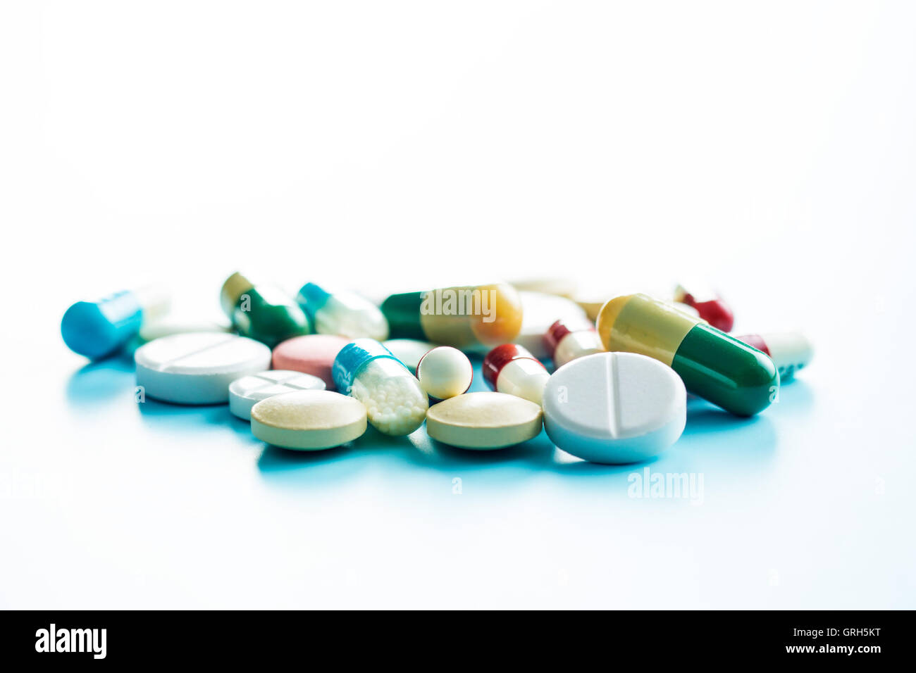 Le diverse pillole su sfondo blu. Foto Stock