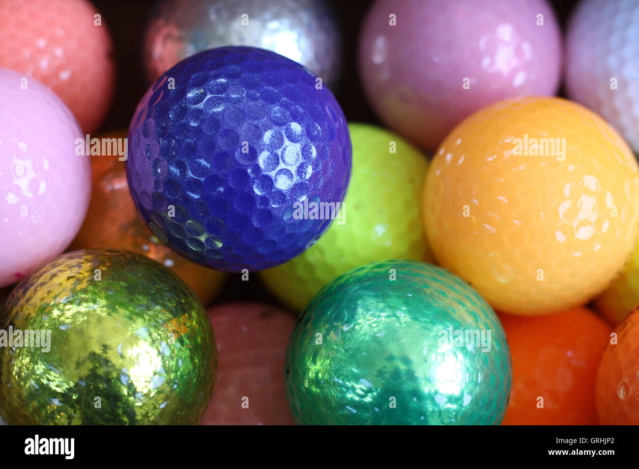 Coloratissime palle da golf, il viola, l'arancione, pesca, verde, oro, rosa, argento Foto Stock