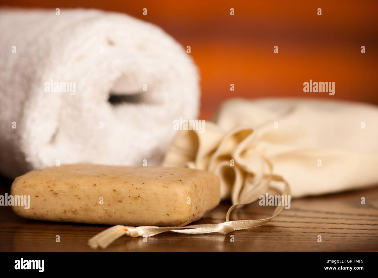 Olio di oliva il sapone con un asciugamano su una scrivania in legno Foto Stock