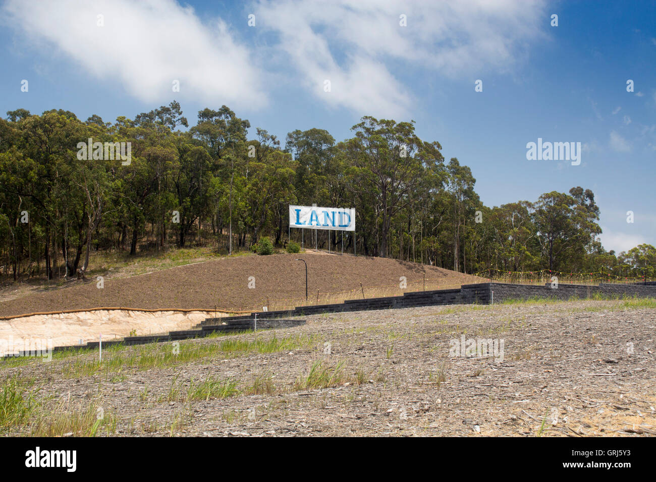 Segno di terra terra per la vendita lo sviluppo immobiliare Vendita di terreni di alberi di eucalipto foresta macchia bush dietro NSW Australia Foto Stock