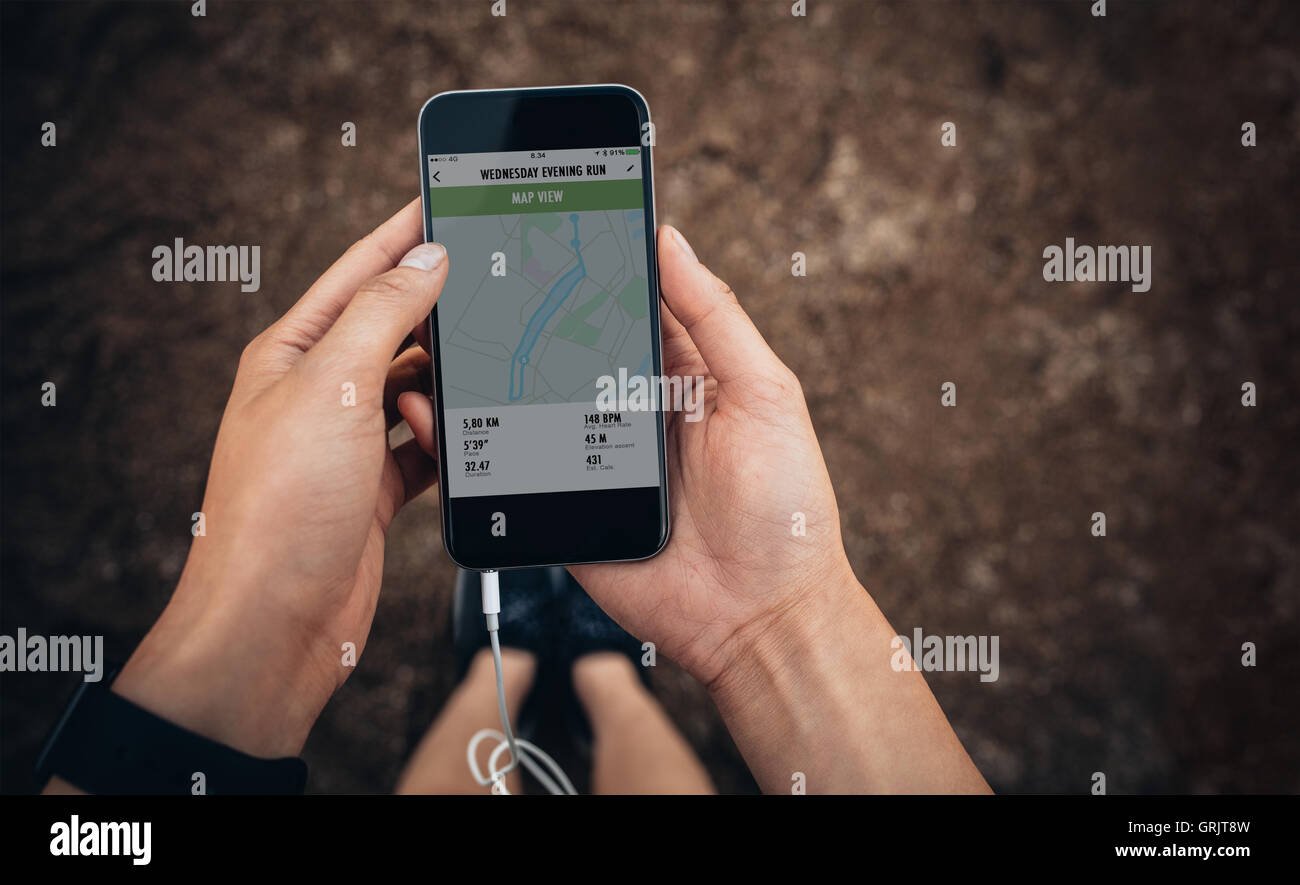 Immagine ravvicinata di controllo femmina la sintesi della sua esecuzione su telefono cellulare. Donna runner utilizzando un app fitness sul suo smartphone. POV Foto Stock Immagine ravvicinata di controllo femmina la sintesi della sua esecuzione su telefono cellulare. Donna runner utilizzando un app fitness sul suo smartphone. POV Foto Stock