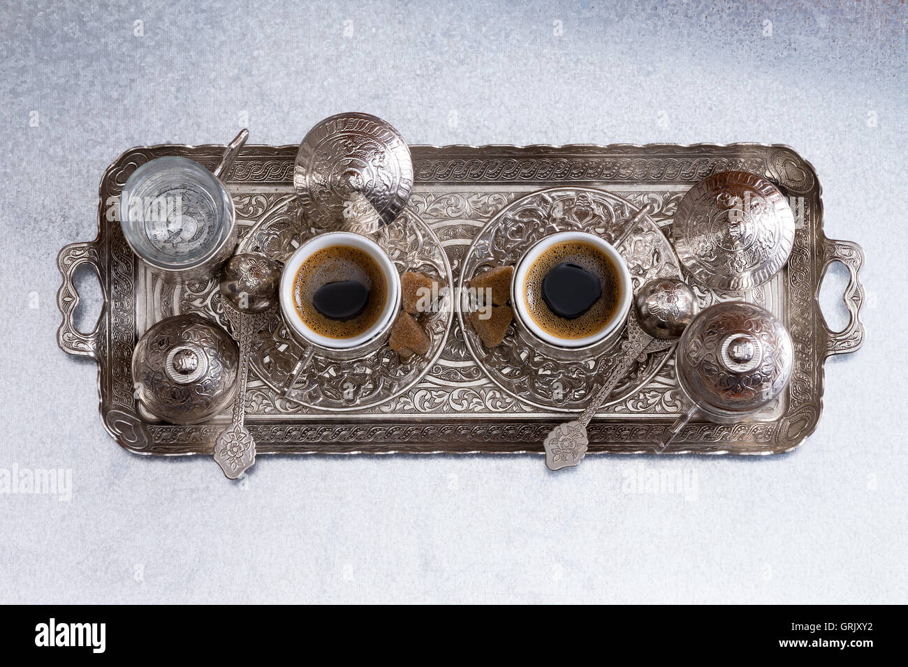 Il caffè turco per due persone servita su un vassoio di metallo con un tradizionale modello di ornati e corrispondenza di tazze e piattini, vista aerea cen Foto Stock