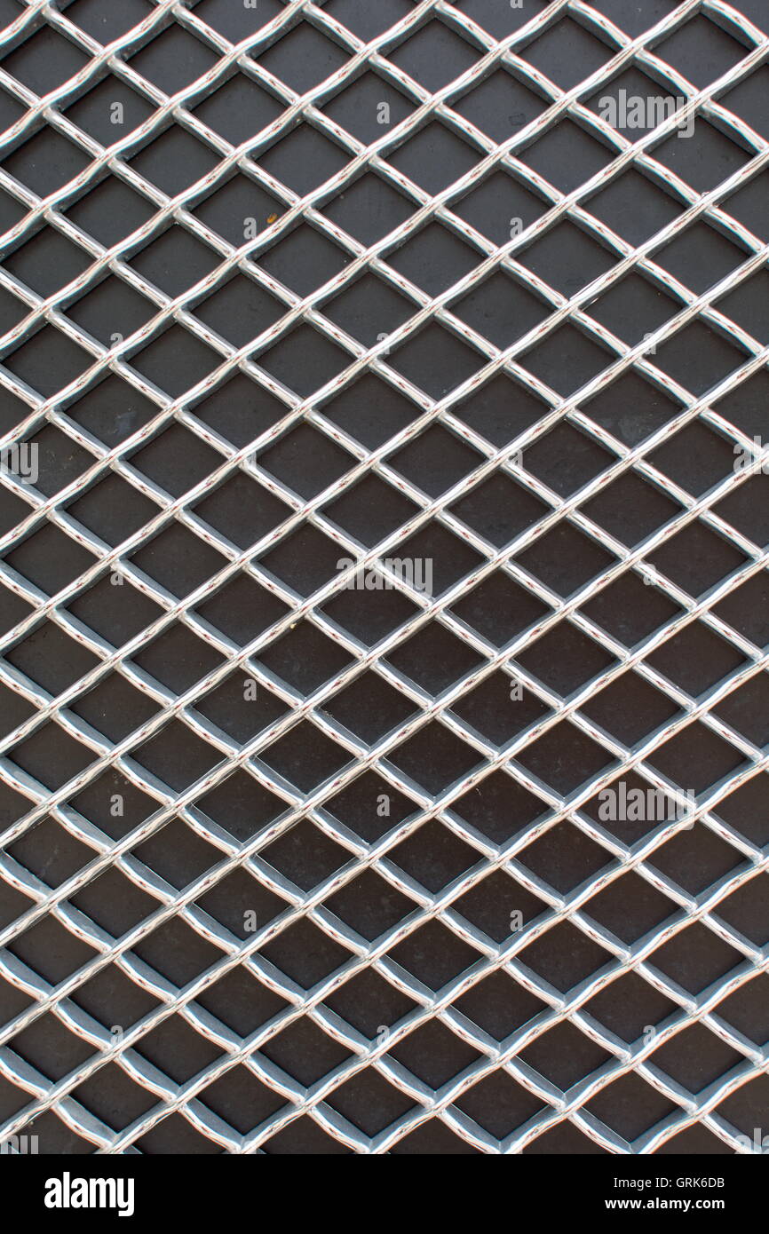 Fotografia di rombo griglia metallica modello sulla superficie nera Foto Stock