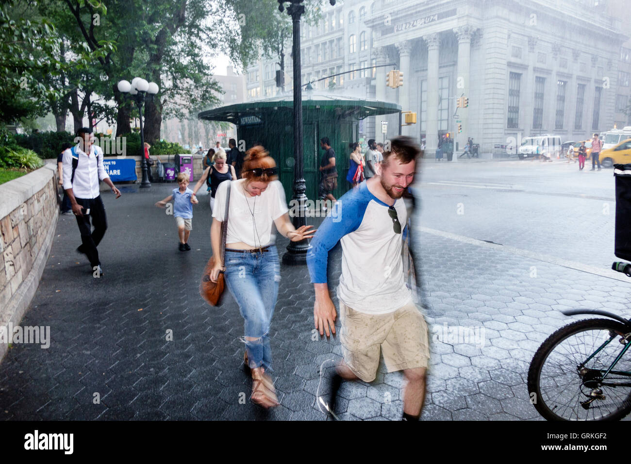 New York City,NY NYC,Manhattan,Midtown,Union Square,zona pedonale,strada trafficata,pioggia improvvisa,acquazzone,corsa,copertura,Black Blacks Africa Foto Stock