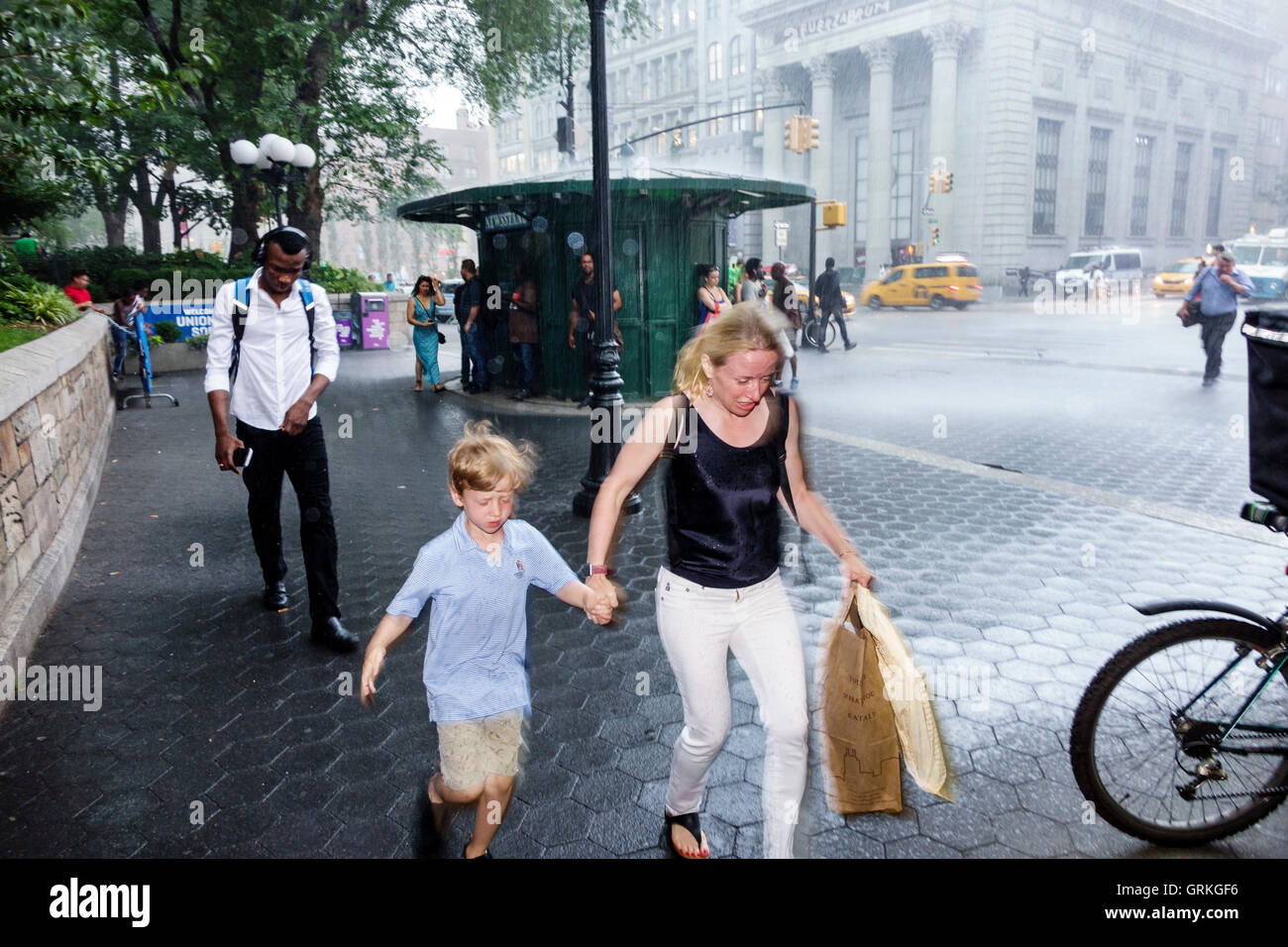 New York City,NY NYC,Manhattan,Midtown,Union Square,pedonale plaza,strada trafficata,pioggia improvvisa,corsa,presa di copertura,neri africani etnici Foto Stock