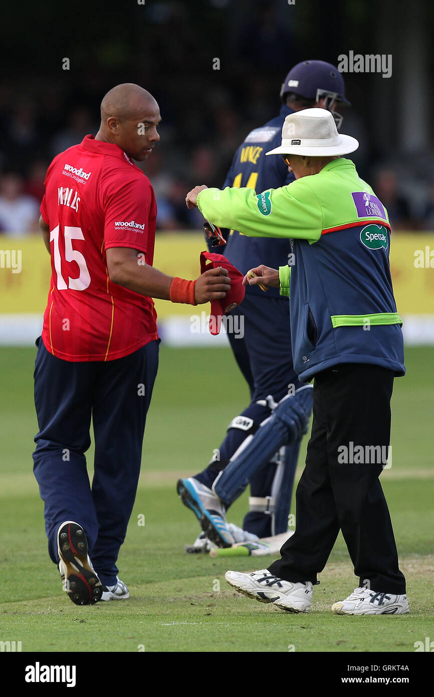 Tymal mulini di Essex (L) prende il suo cappello da arbitro come egli lascia il gioco con un pregiudizio - Essex Eagles vs Hampshire CCC - Royal London One-Day Cup presso l'Essex County Ground, Chelmsford Essex - 13/08/14 Foto Stock