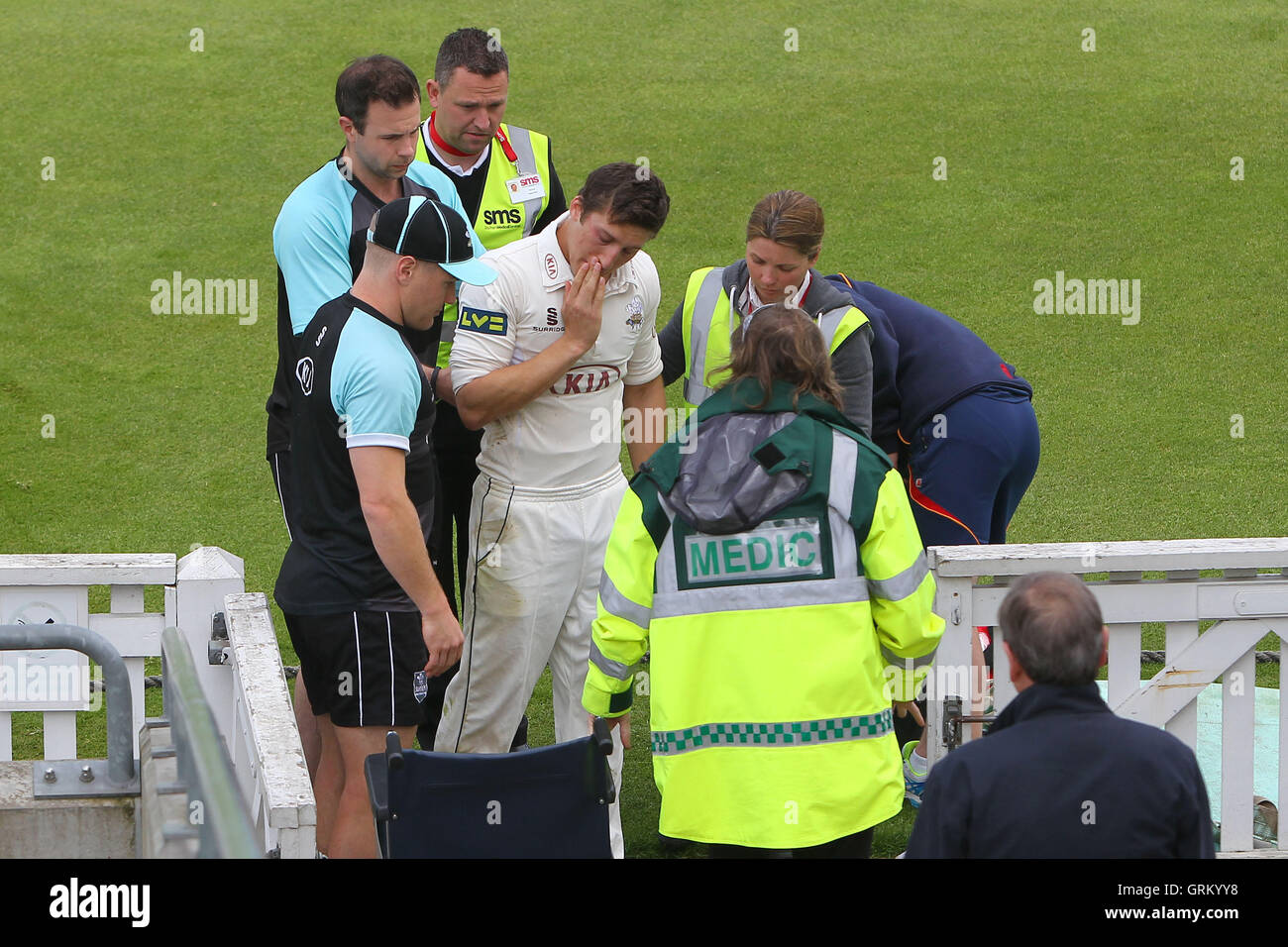 Pregiudizio riguardano per Zafar Ansari di Surrey dopo che egli si scontra con la recinzione di confine la frittura di campo la palla; fortunatamente è stato in grado di distanza a piedi dall'incidente - Surrey CCC vs Essex CCC - LV County Championship Division due Cricket alla Kia ovale, Kennington, Londra - 21/04/14 Foto Stock
