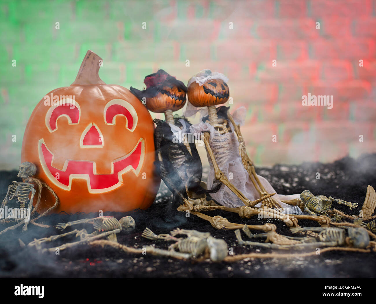 Zucca di Halloween con un Mr & Mrs zucca bambole scheletro seduto accanto ad esso Foto Stock