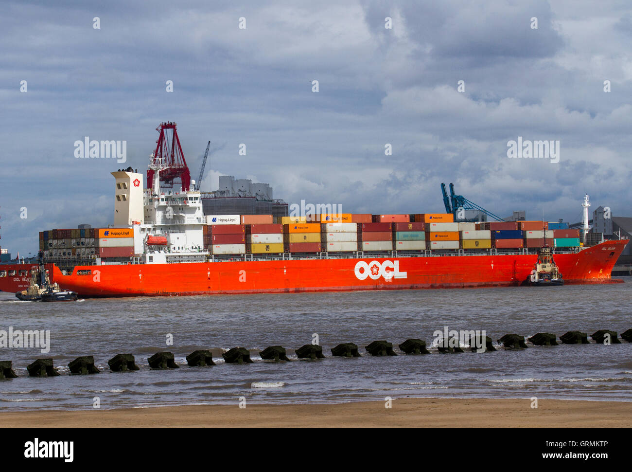 Svitzer Millgarth & Ashgarth rimorchiatori ormeggio Hong Kong OOCL BELGIO contenitore di spedizione nave, importazioni commerciali a Peel porti nel fiume Mersey, Liverpool, Merseyside, Regno Unito Foto Stock