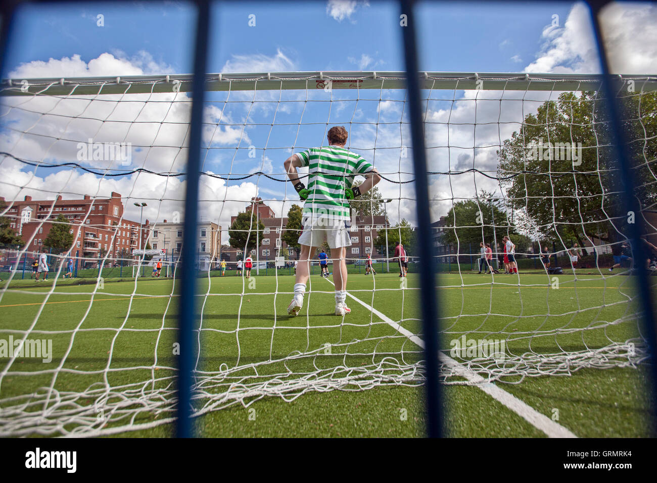 Calcio dilettante, portiere visto attraverso reti da porta, erba artificiale Foto Stock