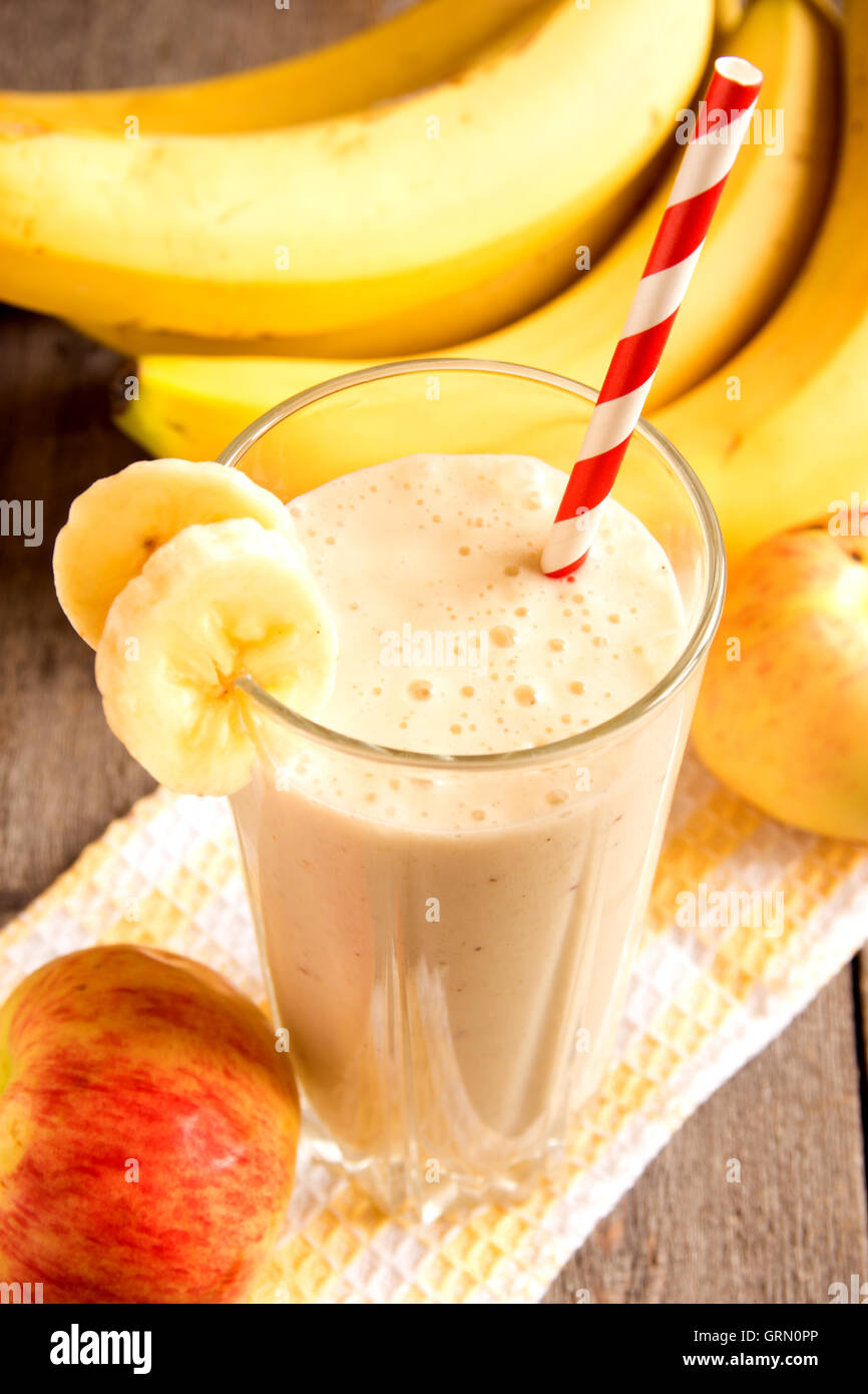 Frullato di frutta (banana, mela, pesca) su sfondo di legno Foto Stock