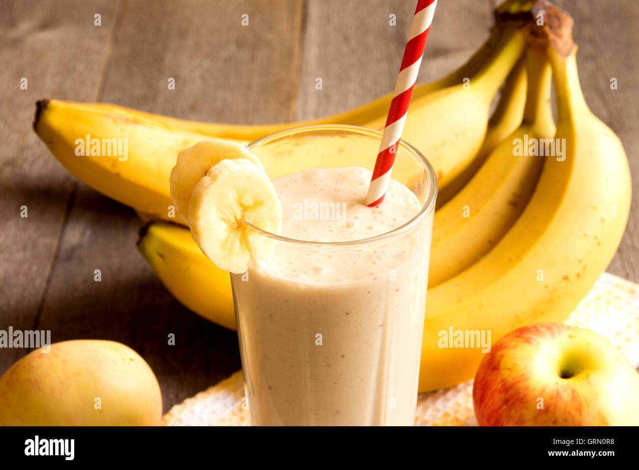 Frullato di frutta (banana, mela, pesca) su sfondo di legno Foto Stock