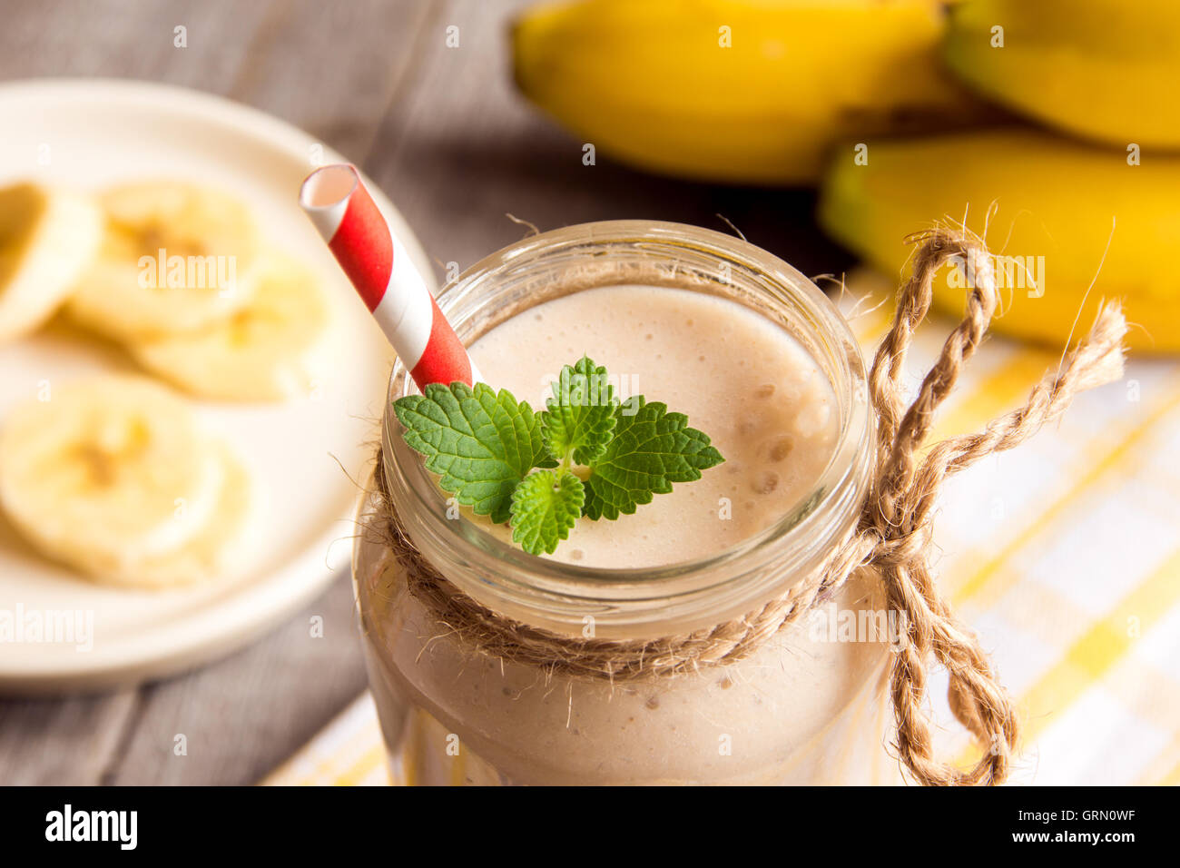 Frullato di banana con menta su sfondo di legno Foto Stock