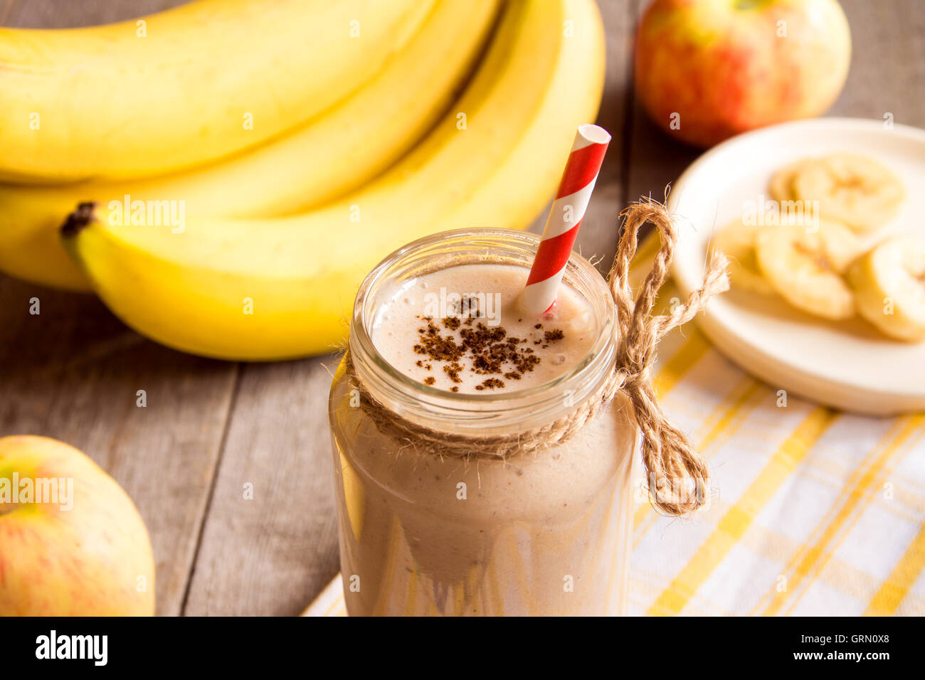 Frullato di frutta (banana, mela, pesca) con cannella su sfondo di legno Foto Stock