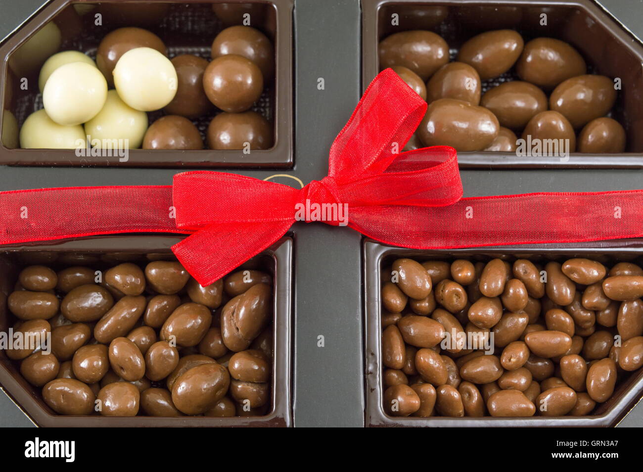 Scatola di cioccolatini in un presente scatola con nastro legato Foto Stock