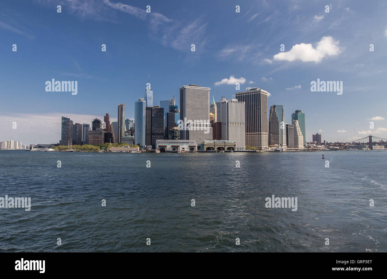 La Staten Island Ferry e Governor's Island Ferry terminali nella parte anteriore di alti edifici di uffici del centro cittadino di Manhattan. Foto Stock