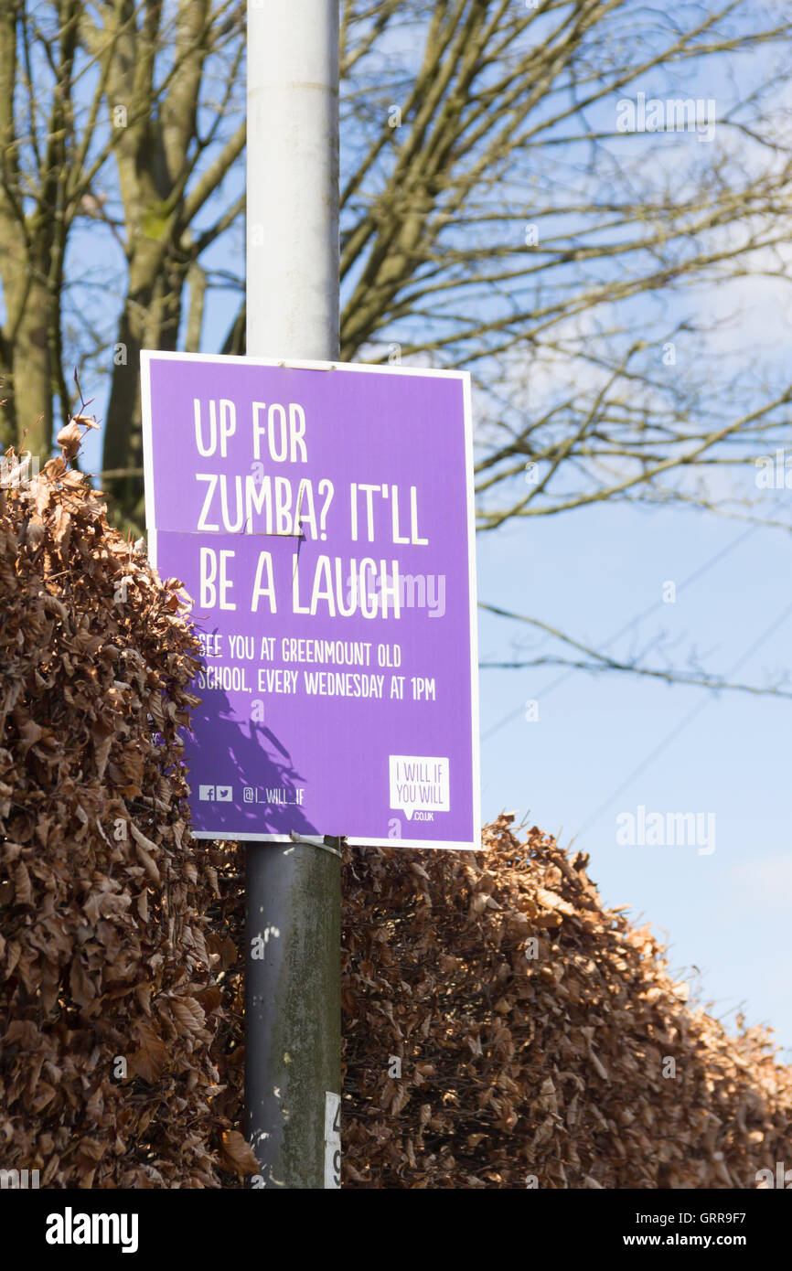 Per Zumba poster pubblicitario su una strada di luce in Greenmount, Bury, Lancashire. Zumba è una forma di esercizio sulla base di danza. Foto Stock