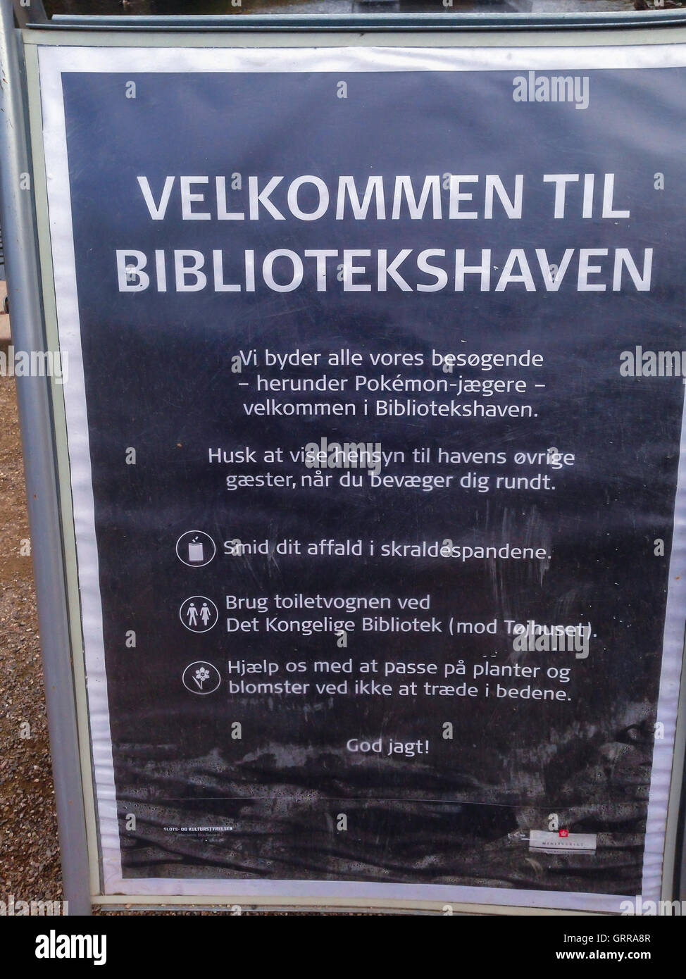 Copenhagen, Danimarca, segno con testo danese, Smart Phone gioco Pokemon andare nel parco pubblico danese (Museo ebraico Giardino) Foto Stock