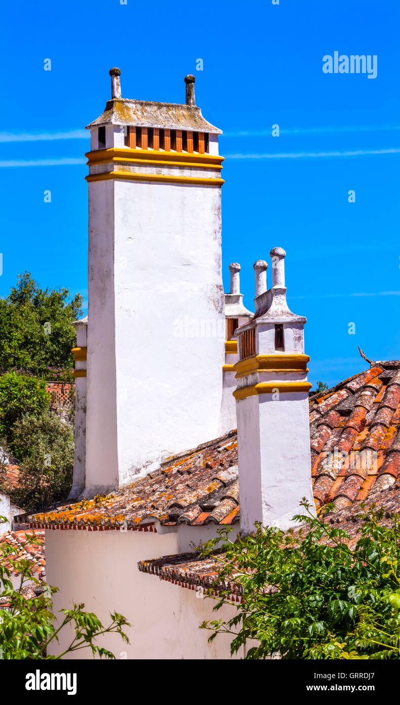 Torri camini tetti arancione cittadina medievale di Obidos Portogallo. Castello e mura costruito nel XI secolo dopo la città prese dalla Moo Foto Stock