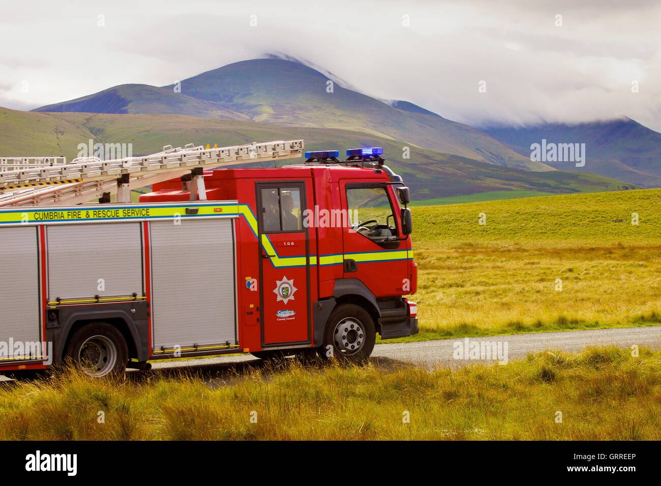 Motore Fire su strada rurale. Aughertree cadde, Uldale, Parco Nazionale del Distretto dei Laghi, Cumbria, England, Regno Unito, Europa. Foto Stock