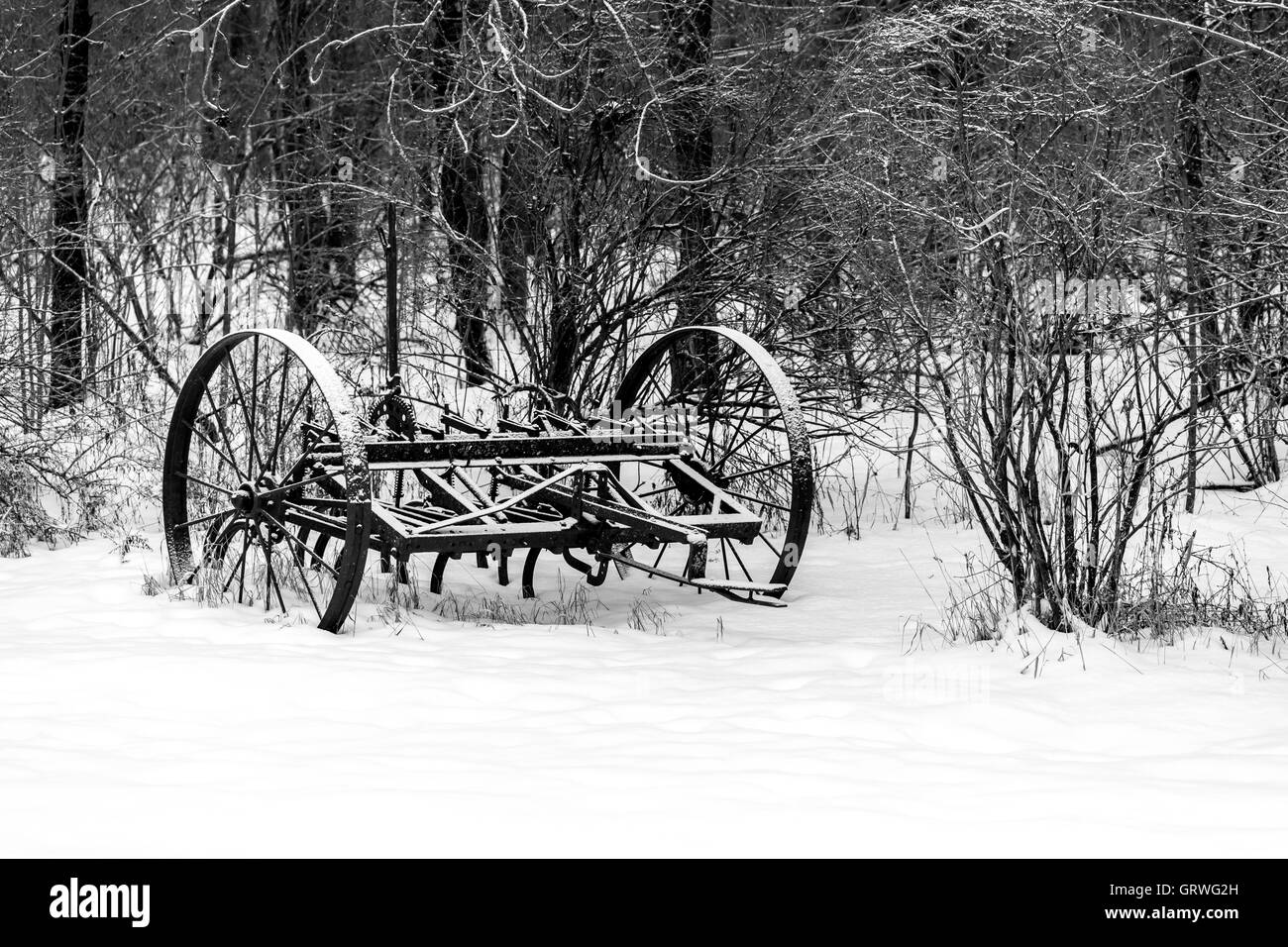 Antico aratro su terreno coltivato nel centro di Wisconsin in inverno. Foto Stock