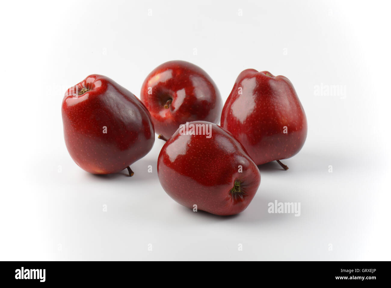 Quattro rosso lucido mele su off - sfondo bianco Foto Stock