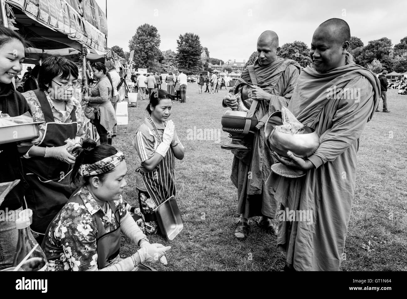 I thailandesi offrono cibo a due monaci al Brighton festival Tailandese, Preston Park, Brighton, Sussex, Regno Unito Foto Stock