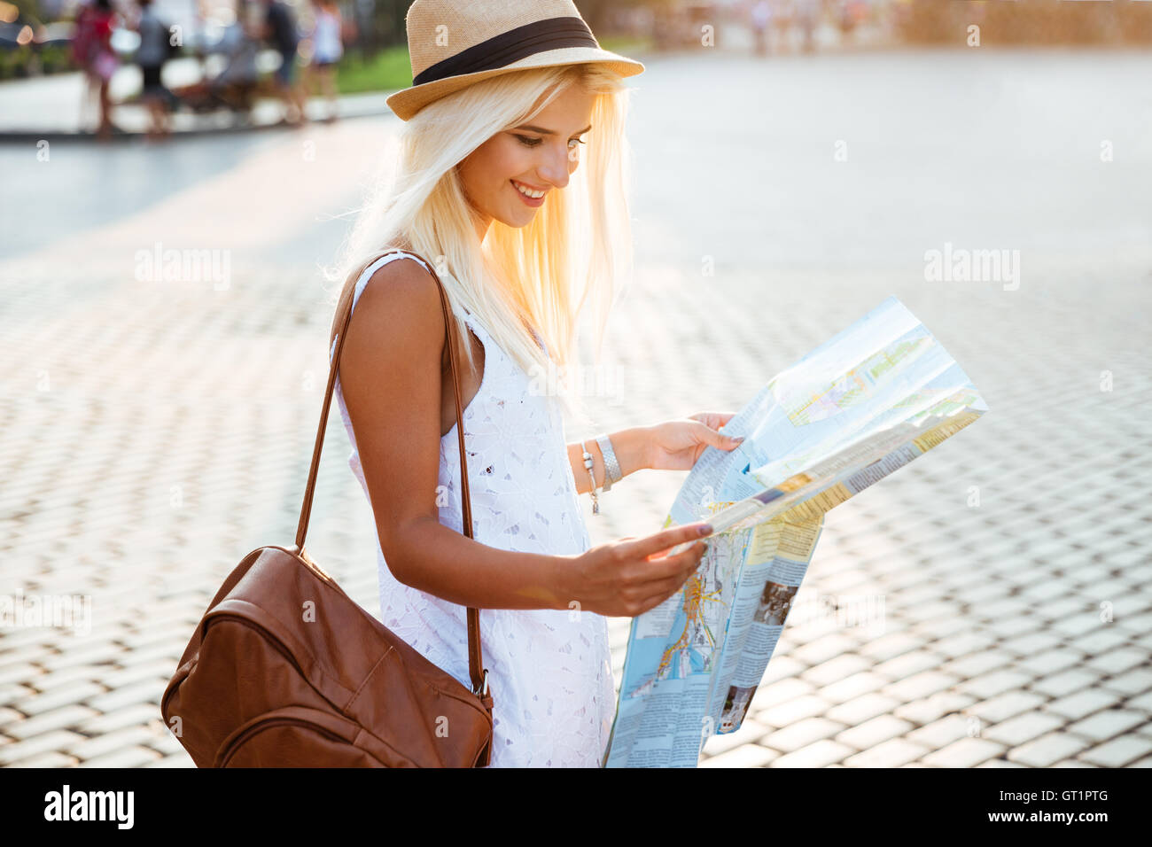 Vista laterale di un felice donna turista in vacanza con la mappa della città in visita Foto Stock