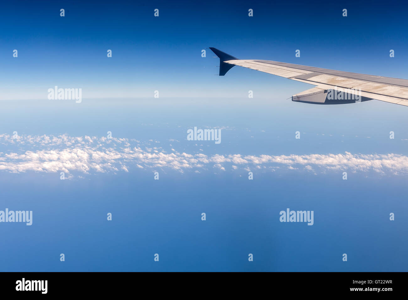 Ala di aeroplano che vola sopra le nuvole nel cielo Foto Stock