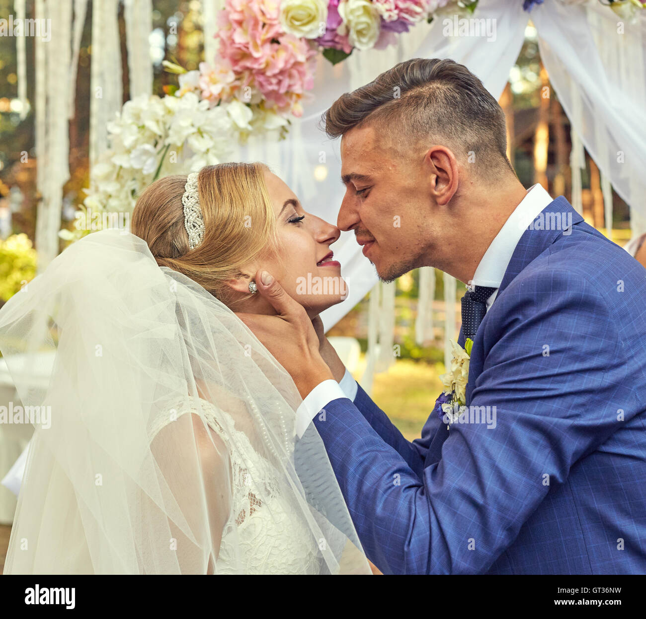 Sposi novelli kissing durante la cerimonia di nozze Foto Stock