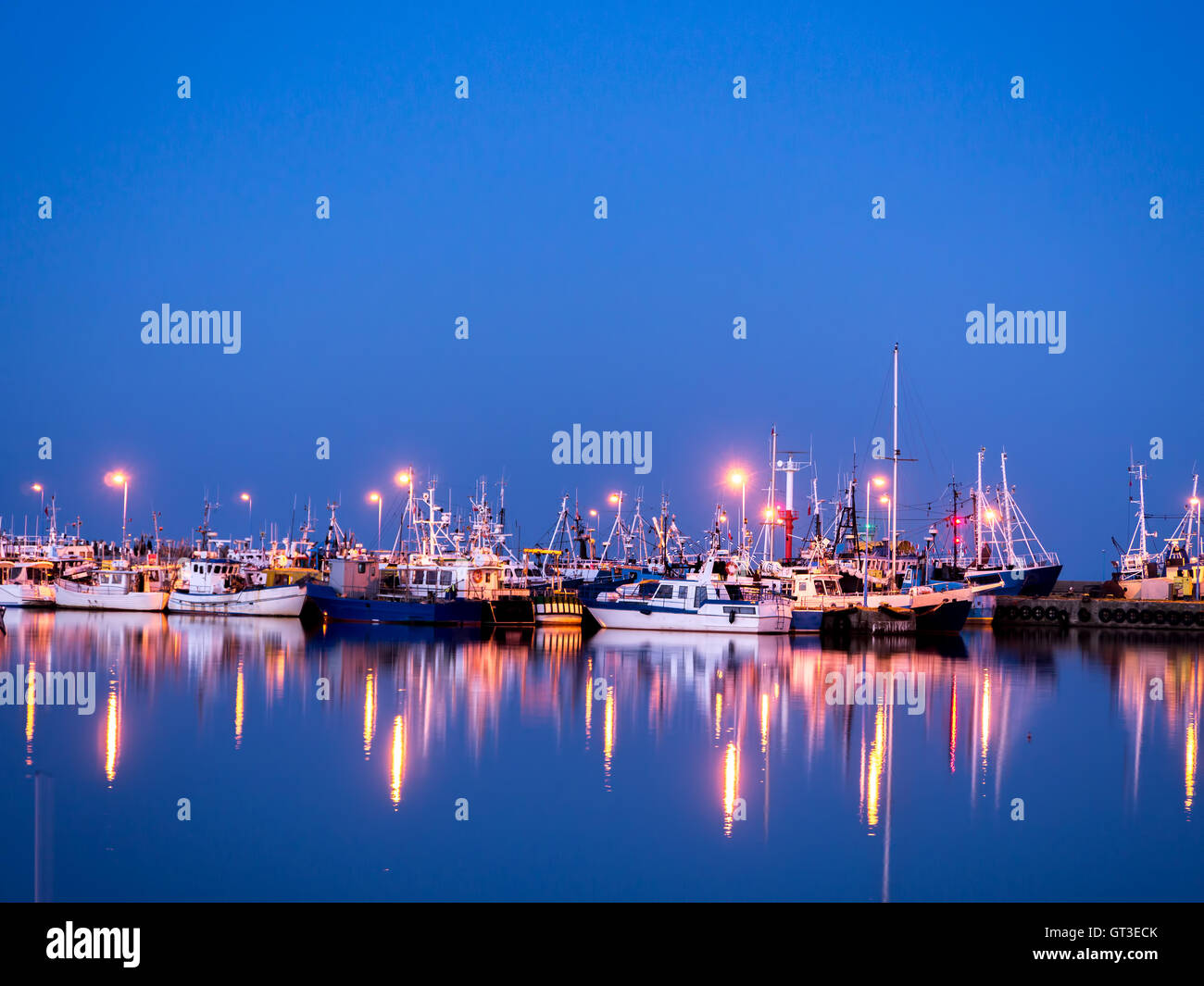 Porto di pesca al crepuscolo con riflessioni Foto Stock