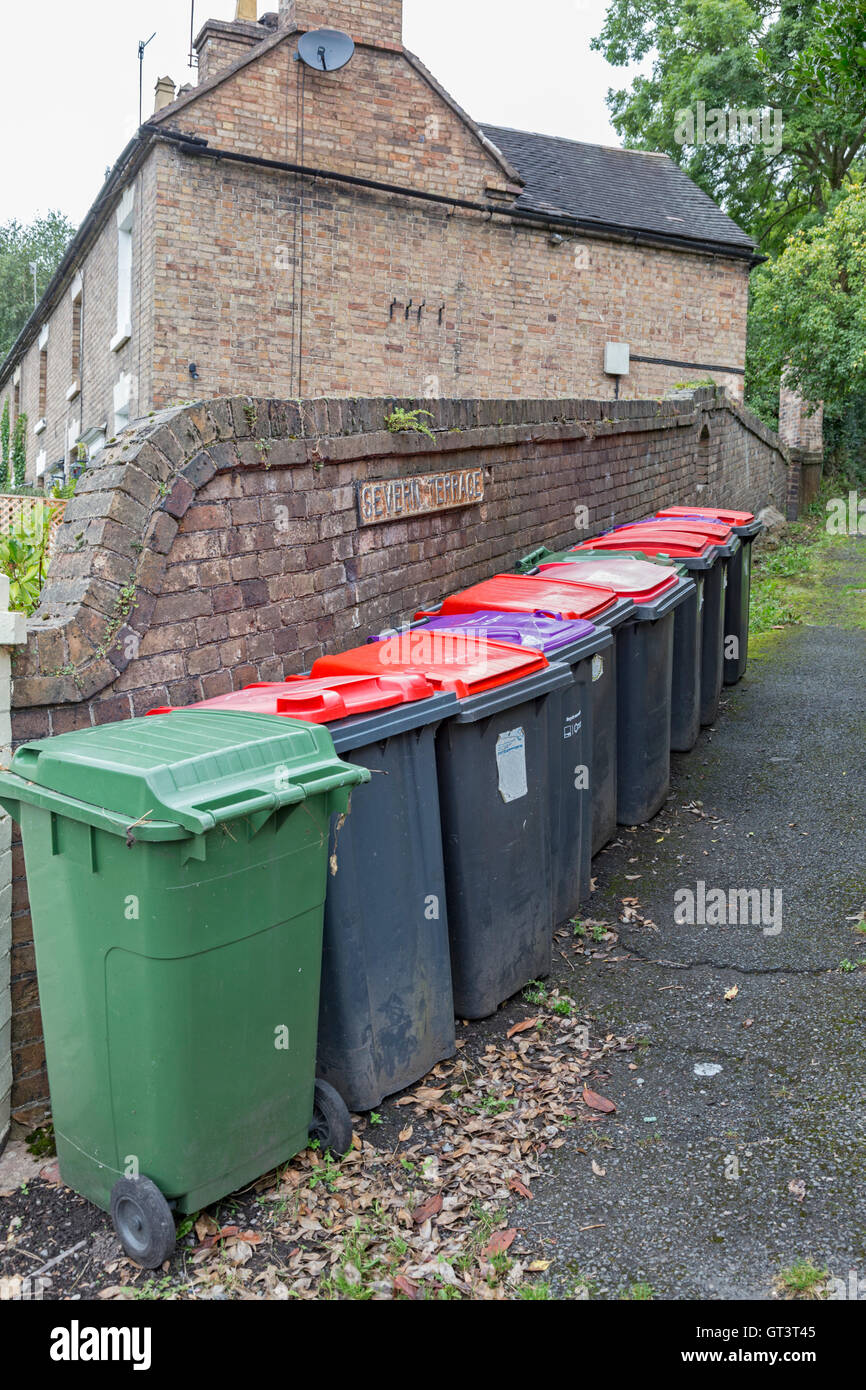 Rifiuti domestici impennata di cassonetti con diversi coperchi colorati, England, Regno Unito Foto Stock