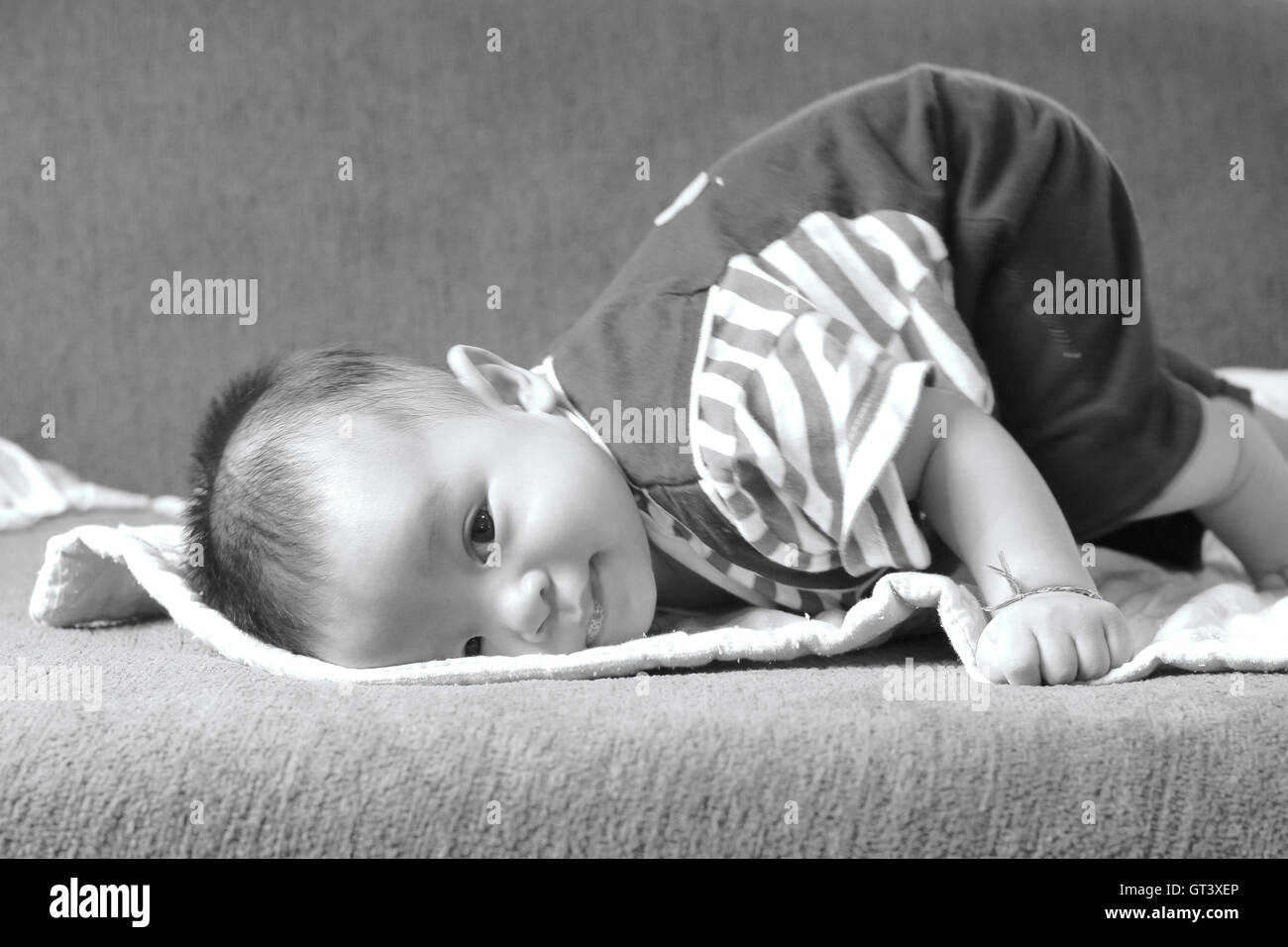 Little baby boy,ritratto di adorabile sorriso curioso baby boy close up in bianco e nero Foto Stock