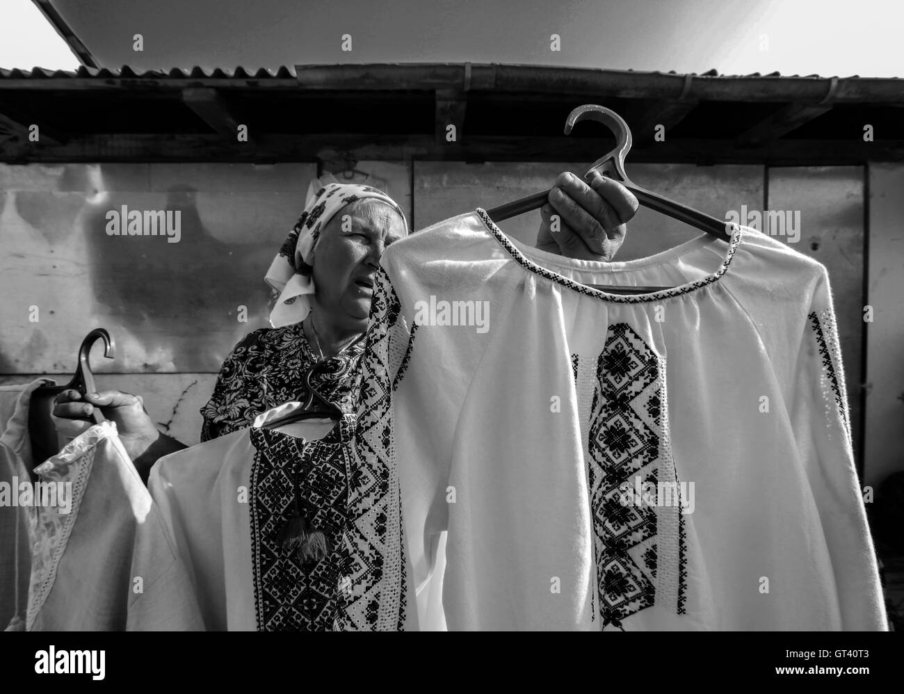 Donna anziana mostra agli acquirenti tradizionali ricamato modello ucraino chemise sul mercato della città di Kosov, Ivano-Frankivsk Foto Stock