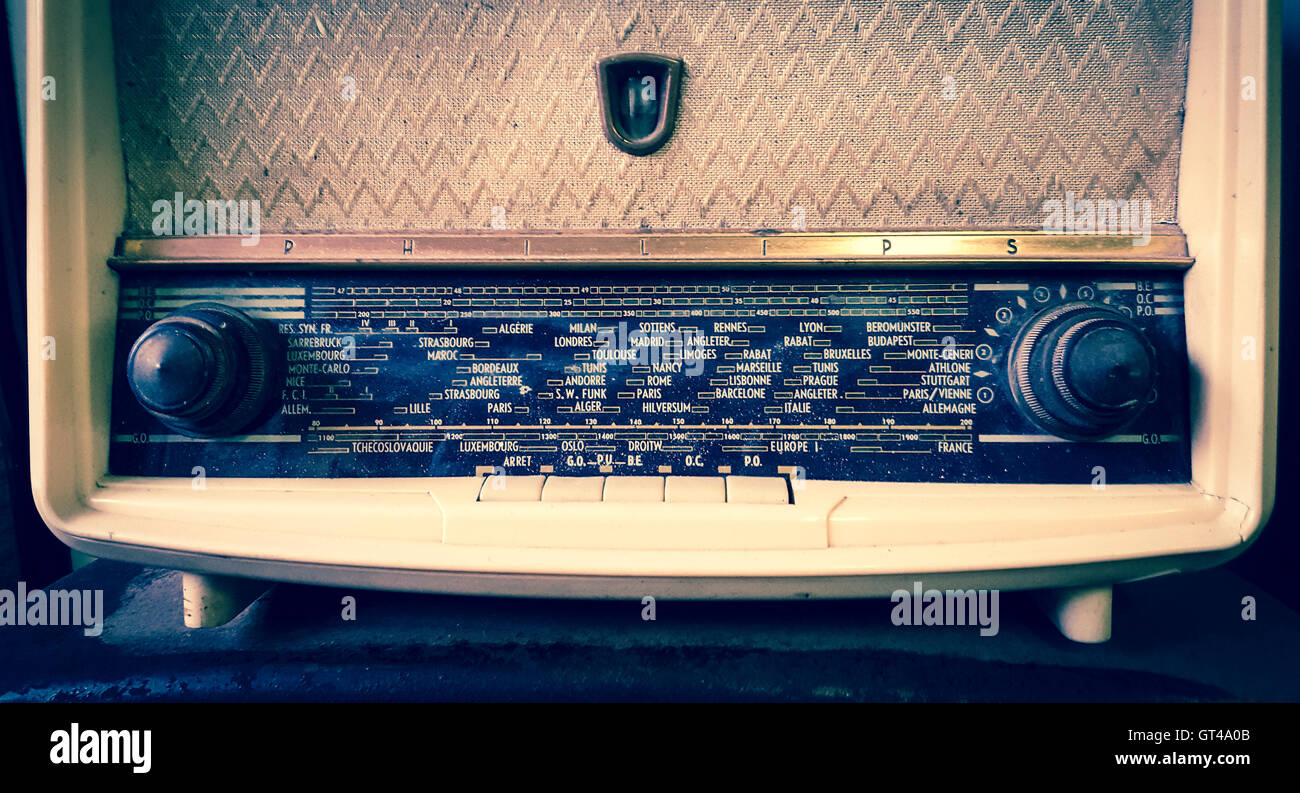Radio d'epoca esposta su uno scaffale in legno in un accogliente soggiorno con illuminazione calda e arredi nostalgici Foto Stock
