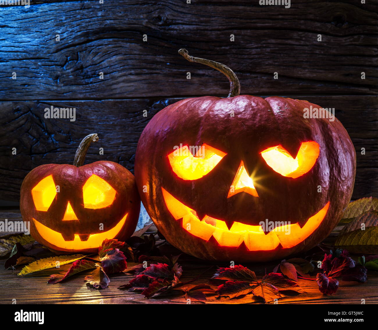 Grinning zucca lanterna o jack-o'-lanterna è uno dei simboli di Halloween. Attributo di Halloween. Sfondo di legno. Foto Stock
