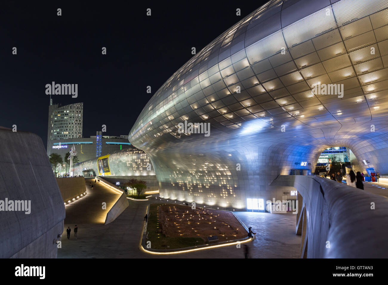 Plaza, il ponte e la vista laterale del futuristico design Dongdaemun Plaza (DDP) a Seul, in Corea del Sud di notte. Foto Stock