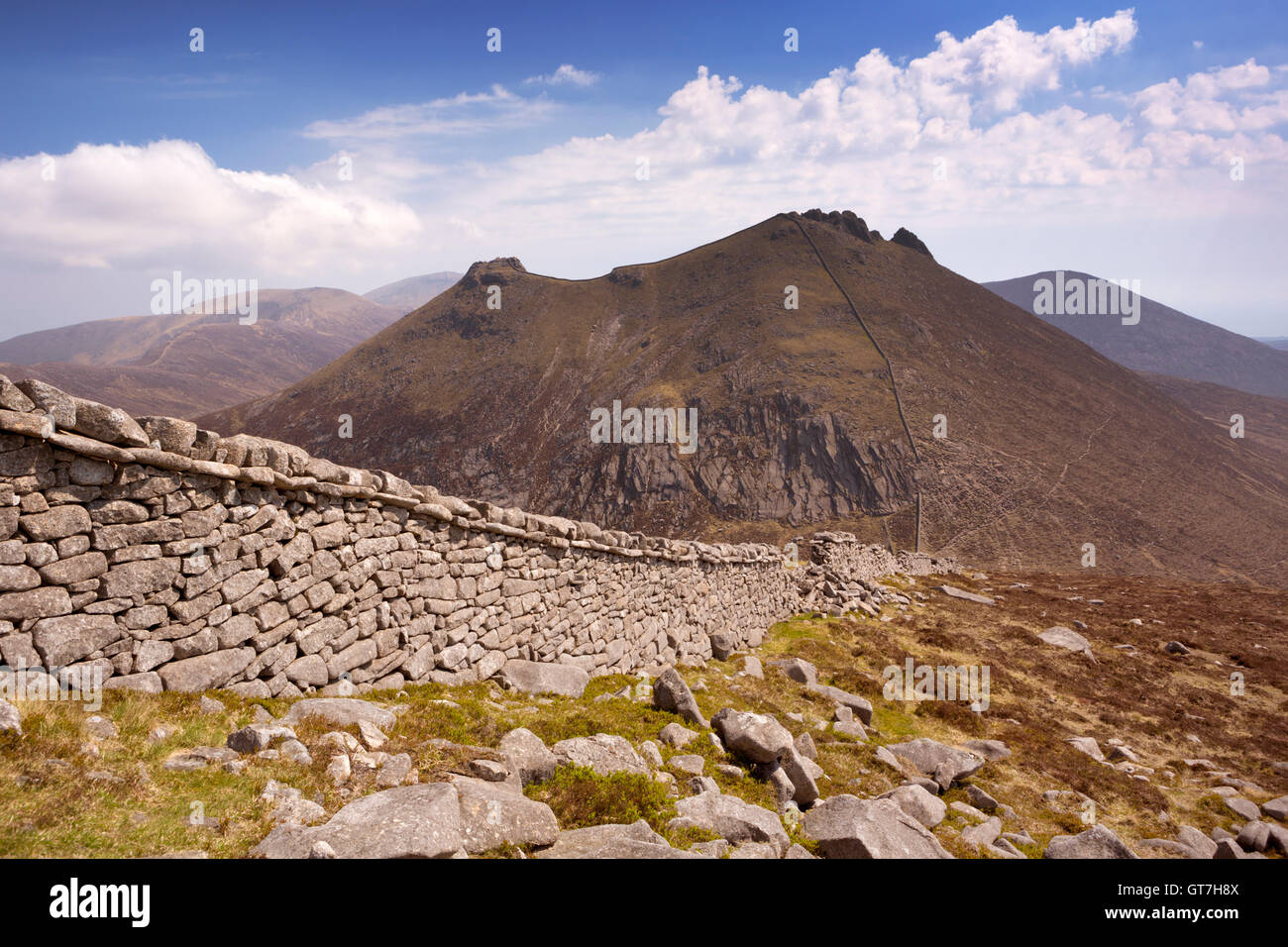La Mourne parete e il picco di Slieve Bearnagh nella Mourne Mountains in Irlanda del Nord in una giornata di sole. Foto Stock