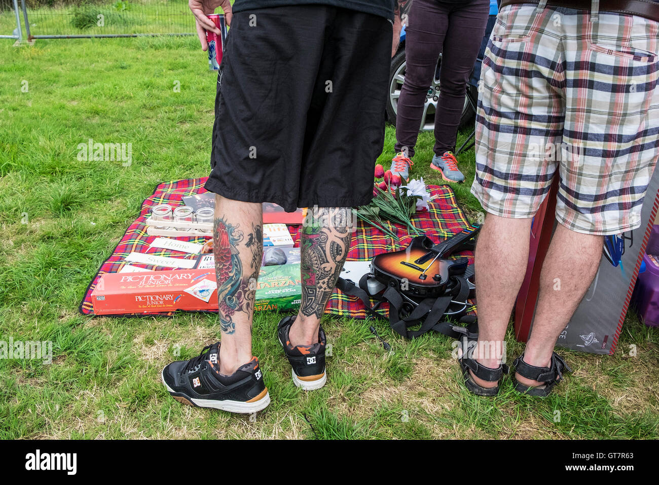 Un uomo con gambe tatuato navigando in una vendita di avvio. Foto Stock