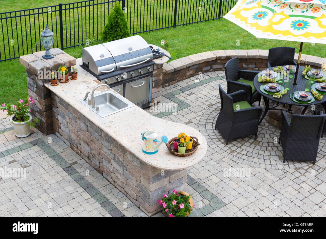 Elevato angolo di visione di un elegante cucina esterna, barbecue a gas e tavolo da pranzo insieme per intrattenere gli ospiti con luogo formale impostazione delle Foto Stock