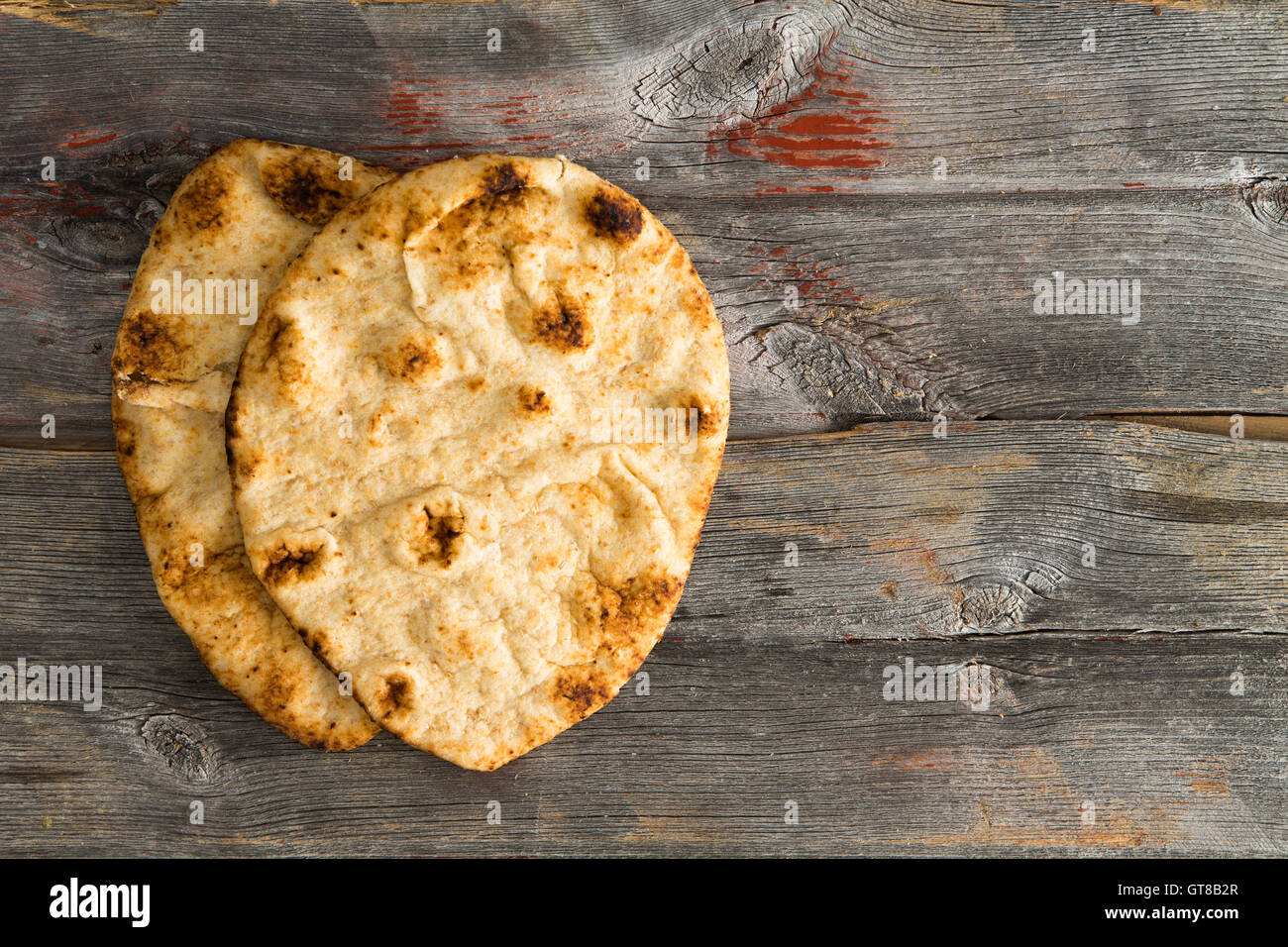 Semplicemente cotti al forno deliziosi crostini di grano intero pane naan focacce, un pane lievitato cotto in un tandoor forno di argilla, servita su autentici o Foto Stock